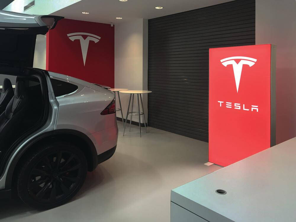 Garage mit einem Auto von Tesla und Stehtische und eine Pixlip Go Lightbox mit Textildruck