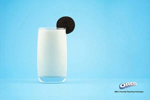 Druck für die Marke Oreo, Glas Milch mit Keks an Kante auf hellblauem Hintergrund